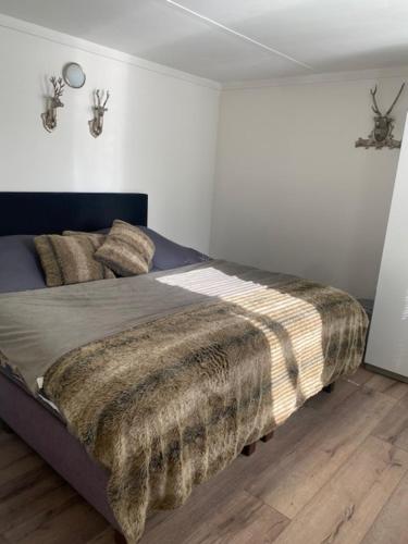 a bedroom with a bed with a blanket on it at HOLTINGERHUYS Havelte- Giethoorn! Tegen betaling Wellness!!! in Havelte