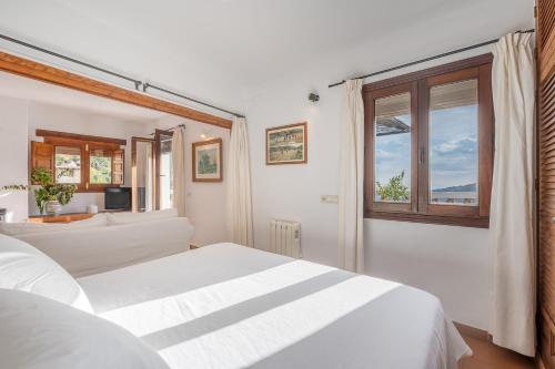 a bedroom with two white beds and a window at Casa Belmonte in Bubión