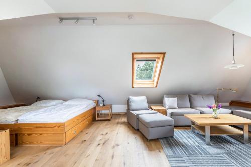 a bedroom with a bed and a couch and a table at Ferienhaus Herich in Nieblum