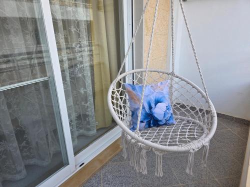 a blue teddy bear sitting in a porch swing at Refúgio Luzia Mar in Santa Luzia