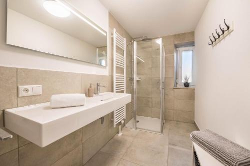 a white bathroom with a sink and a shower at Bezauberndes Gästehaus in Zaisertshofen