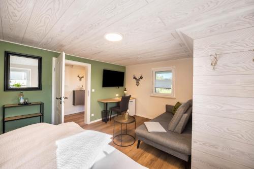 a bedroom with a bed and a couch and a table at Bezauberndes Gästehaus in Zaisertshofen