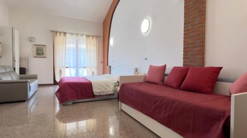 a bedroom with a bed and a couch in a room at B&B La Pitagora in Porto Garibaldi