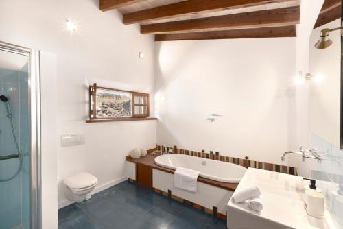 a bathroom with a tub and a toilet and a sink at Las Rocas in Fornalutx