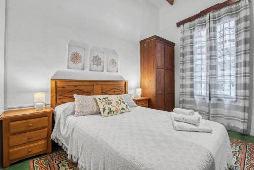 a bedroom with a white bed and a window at La casa de la Sariera in Jávea