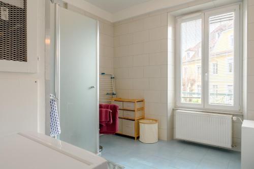 a bathroom with a shower and a window and a sink at Appartement Le 47 in Thann