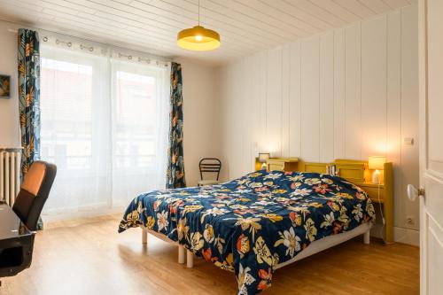 a bedroom with a bed and a large window at Appartement Le 47 in Thann