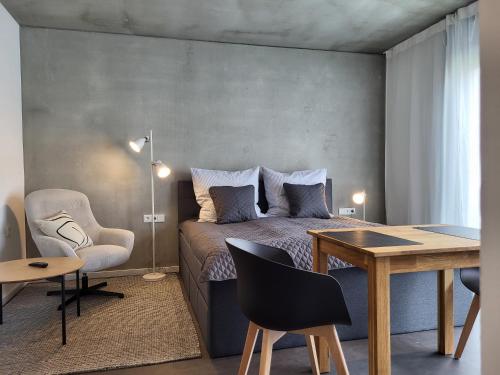 a bedroom with a bed and a table and a desk at Apartment Schlossterrassen 8a in Pouch