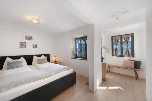 a bedroom with a large bed and two windows at Apartment Am Grübl in Lana