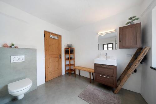 a bathroom with a sink and a toilet and a mirror at Apartment Am Grübl in Lana