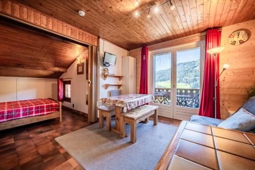 a bedroom with a bed and a table and a window at Chalet Arnica in Morzine