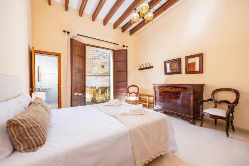 a bedroom with a white bed and a piano at Cas Sitger in Felanitx