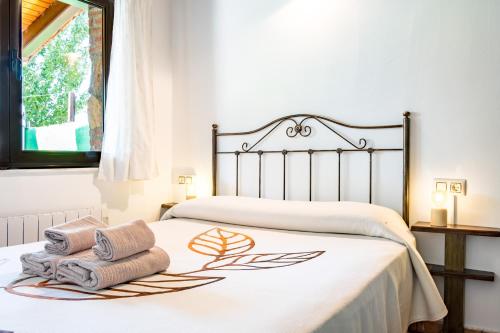 a bedroom with a bed with towels on it at La Casa del Carpintero in Zarapicos