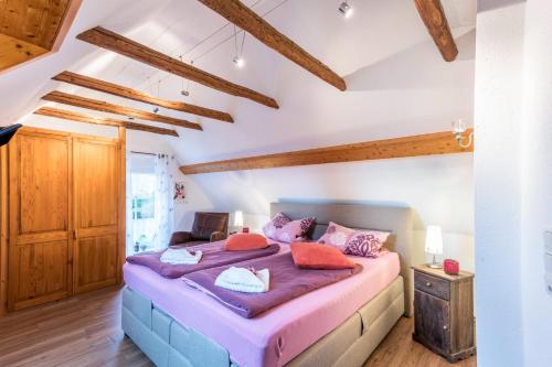 a bedroom with a large bed in a room with wooden ceilings at Ferienwohnung Adler in Wirdum