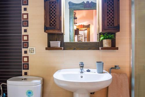 a bathroom with a sink and a toilet and a mirror at La Casa del Carpintero in Zarapicos