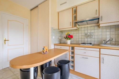 a kitchen with a wooden table and some stools at Appartement Numéro 1 - piscine in Valbonne