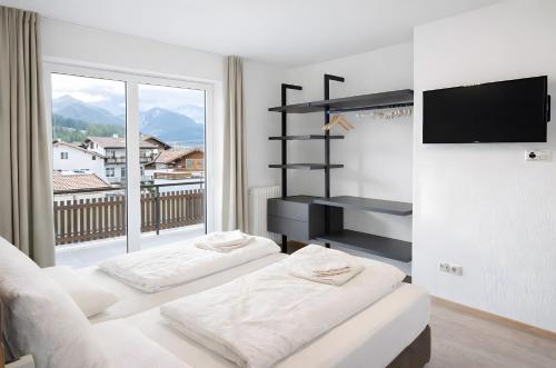 a living room with two beds and a large window at Premium App Hofer Barbara in Villabassa