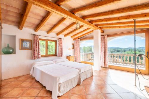 a bedroom with a bed and a large window at Finca Can Menut in Felanitx
