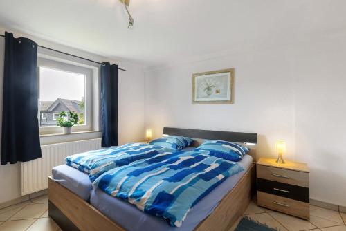 a bedroom with a bed with blue and white sheets at Ferienwohnung Lichte in Medebach