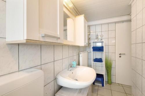 a white bathroom with a sink and a toilet at Ferienwohnung Lichte in Medebach