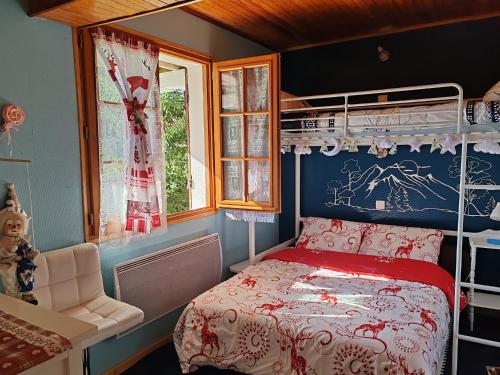a bedroom with a bunk bed with a red and white bedspread at Chalet Vététiste in Laveissière