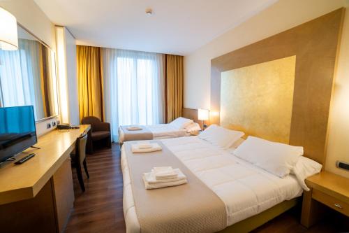 a hotel room with a large bed and a television at Hotel Tiffany Milano in Trezzano sul Naviglio