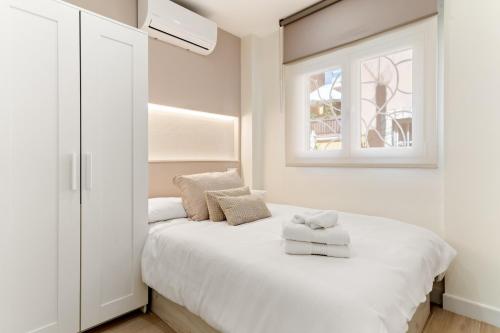 a bedroom with a white bed with two towels on it at Cala Azul-few steps from the beach in La Cala de Mijas