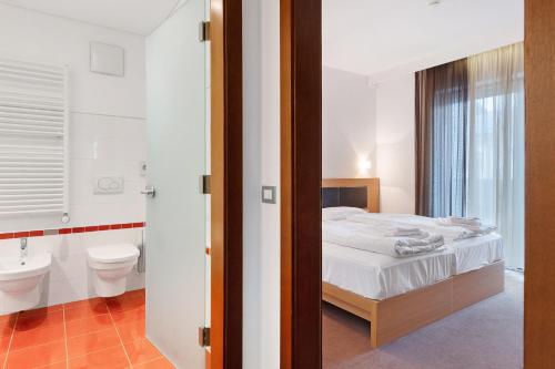 a bedroom with a bed and a bathroom with a toilet at Residence Alpenrose in Col di Villa