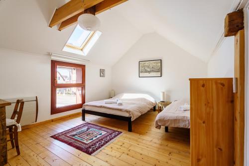 a bedroom with two beds and a window at Bnb Au Petit Ruisseau in Plobsheim