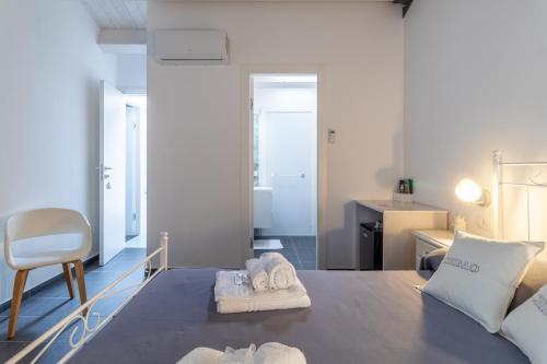 a room with a bed with towels and a chair at Chibao House con piscina privata in Ragusa