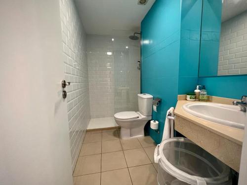 a bathroom with a white toilet and a sink at CasaFelix in Corralejo