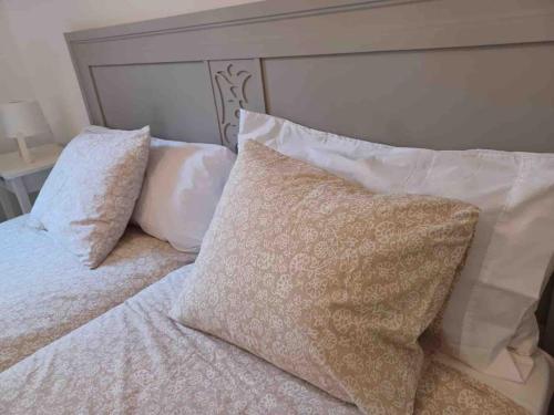 a bed with white pillows and a head board at CasaFelix in Corralejo