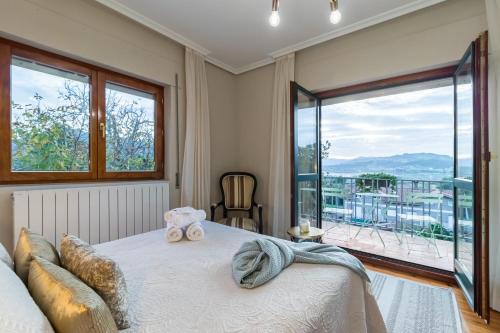 a bedroom with a bed and a large window at Casa La Quinta in Colindres