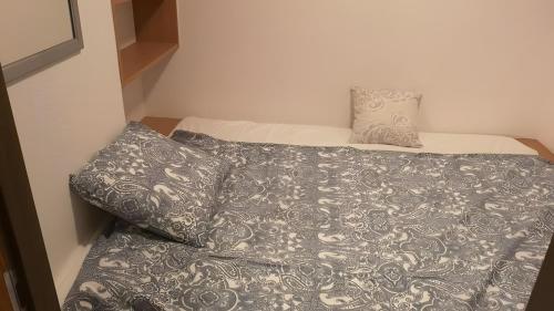 a bed with a gray blanket and two pillows at Appartement Simonhöhe mit Pool in Zirkitz