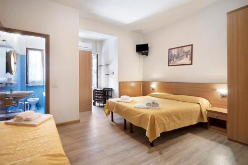 a hotel room with two beds and a bathroom at Appartamento Monolocale Moneglia 35 in Moneglia