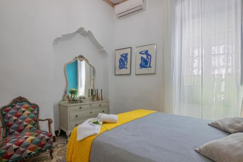 a bedroom with a bed and a chair and a mirror at Una casa azul in Manzanilla