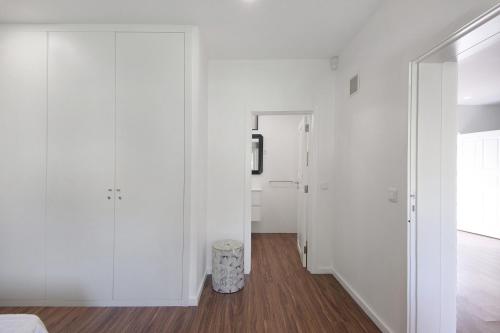 a white room with white walls and a mirror at Moradia Pinheiro Manso in Apúlia
