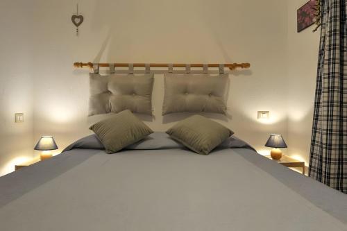 a bedroom with a large white bed with two lamps at Maison Wanda La Salle in La Salle