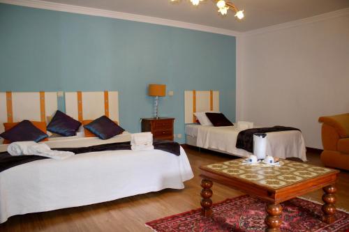 a hotel room with two beds and a table at Solar de Rabal in Bragança