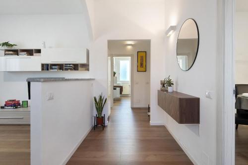 a living room with white walls and a hallway with a mirror at Dante210 in Cassina Rizzardi