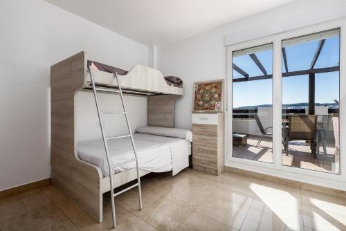 a bedroom with a bunk bed and a balcony at Atico Duplex con terraza in Manilva