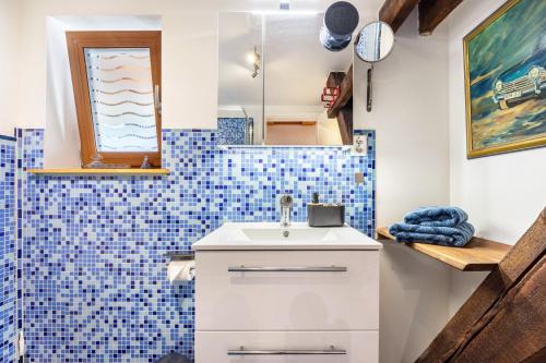 a bathroom with a sink and a blue tiled wall at Offene Galerie-Fewo auf 2 Etagen in Bad Gandersheim