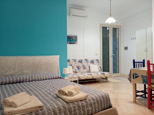 a bedroom with a bed and a blue wall at Maison d'O in Otranto