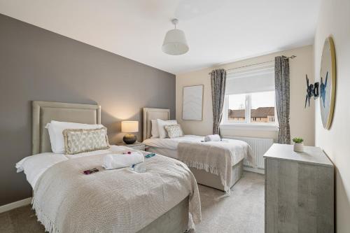a bedroom with two beds and a window at Lees Apartment in Coatbridge