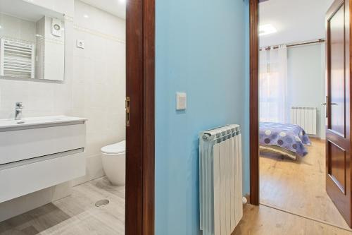 a bathroom with a toilet and a sink at Vivienda Turística Osiris in San Andrés del Rabanedo