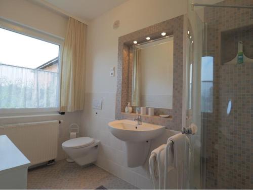 a bathroom with a sink and a toilet and a shower at Ferienwohnung Koppelblick in Plattenburg