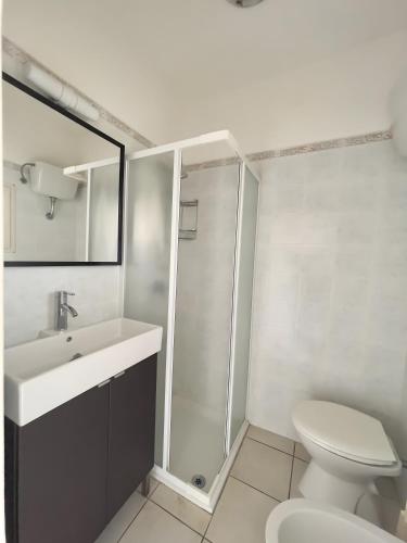 a bathroom with a toilet and a sink and a shower at Monolocale Sergi- Piscina In Comune in Stintino