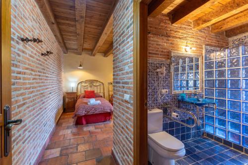 a bathroom with a toilet and a bed in a room at La Tarja in Martín Miguel