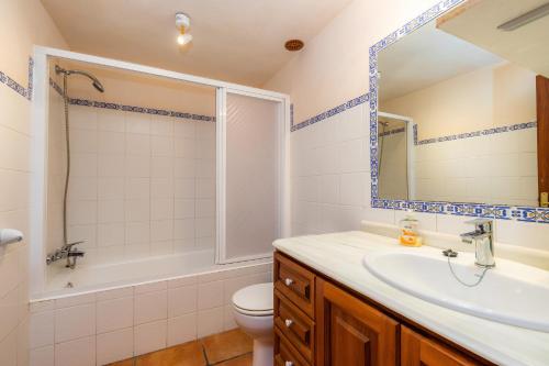 a bathroom with a sink and a toilet and a mirror at Finca Galardo in Son Servera