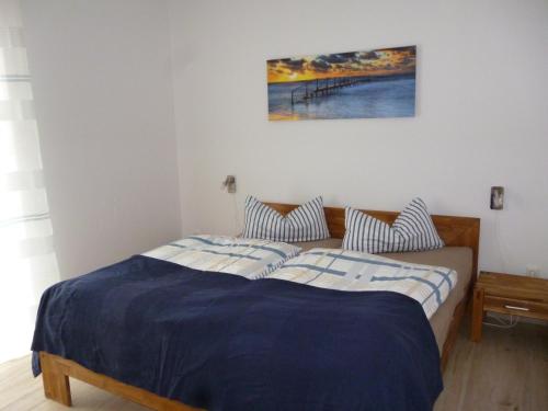 a bedroom with two beds and a painting on the wall at Ankerhaus mit Sauna und Kamin in Karlshagen